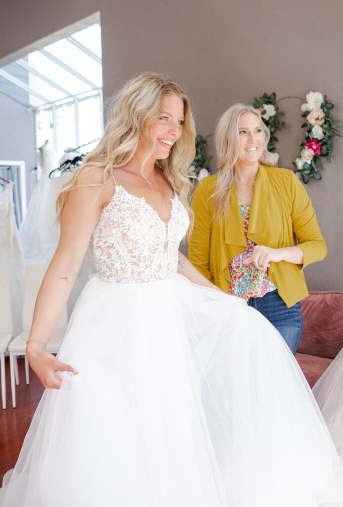 Bride trying on wedding dresses with her Bridal Consultant. Weddings with Joy.