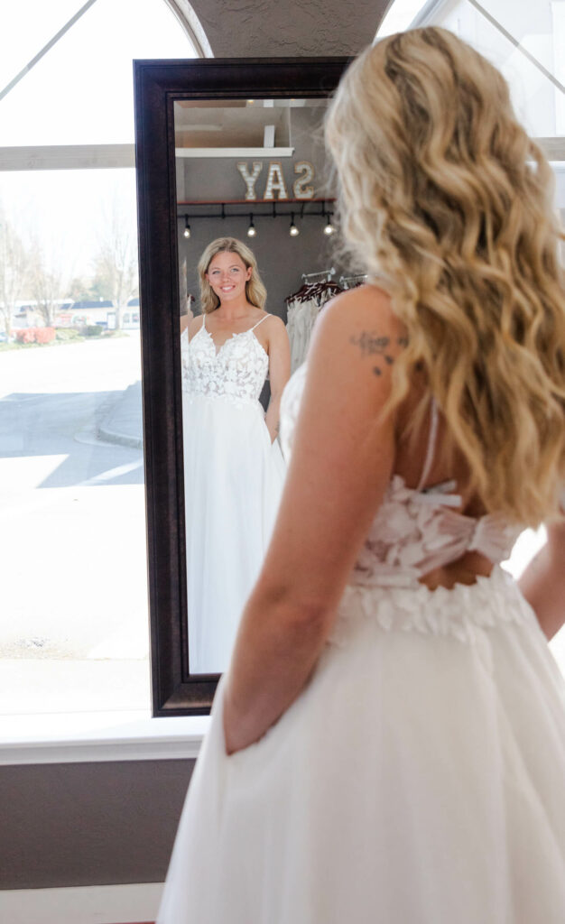 bride tries on floral lace wedding dress. Weddings with Joy