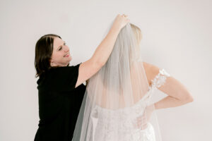 Courtney Foreman helping bride with veil