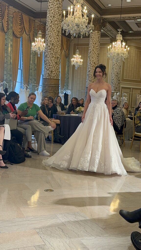 Casablanca Bridal model wearing a beautiful lace wedding dress and walking down the catwalk at the Chicago Bridal Market 2024.