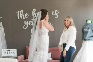 Weddings with Joy bridal stylist workign with Bride to Be in her wedding dress try on appointment.
