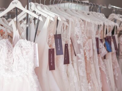 Designer wedding dresses on clothing rack. Weddings With Joy.