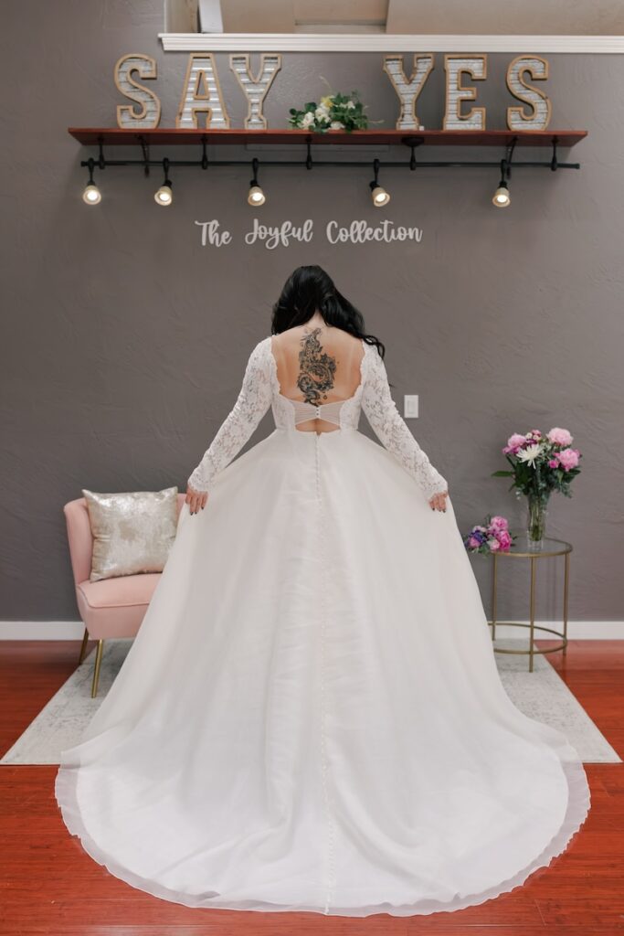 Open back wedding dress with lace bodice and long lace sleeves. Weddings with Joy. 