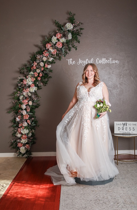 Plus size, a-line wedding dress with v-neck, straps and floral lace detailing. Weddings with Joy. 