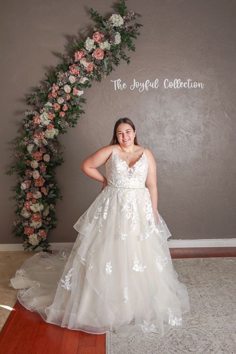 Spaghetti strap wedding dress, floral lace detailing, tiered tulle skirt, plus size. Weddings with Joy. 