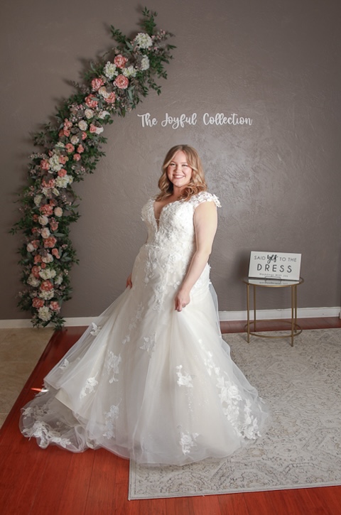 Cap sleeves wedding dress with tulle skirt, lace detailing. Plus size bridal fashion. Weddings With Joy. 