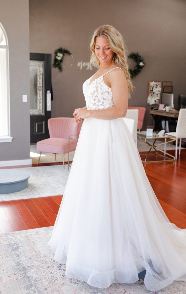 bride in an a-line, lace bodice wedding dress with spaghetti straps. weddings with joy. 