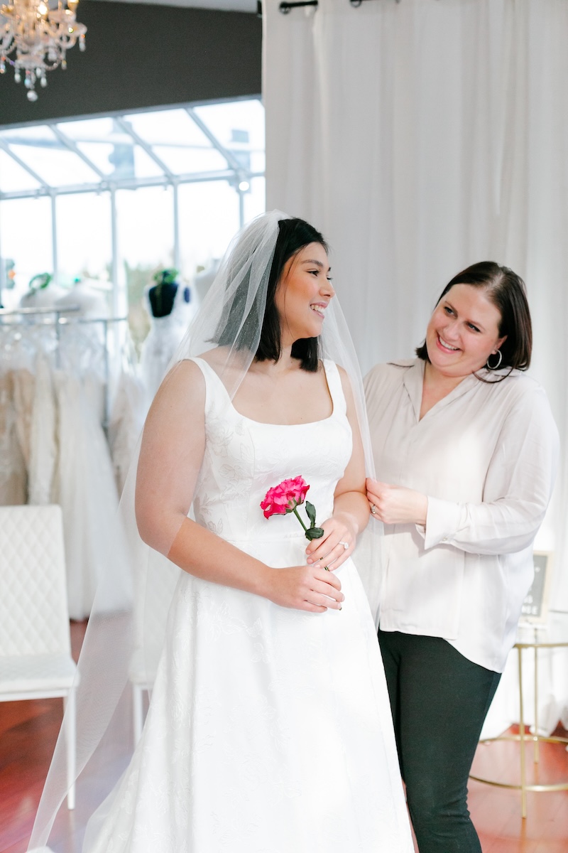 bride tries on jacquard wedding dress with straps. Weddings with Joy. 