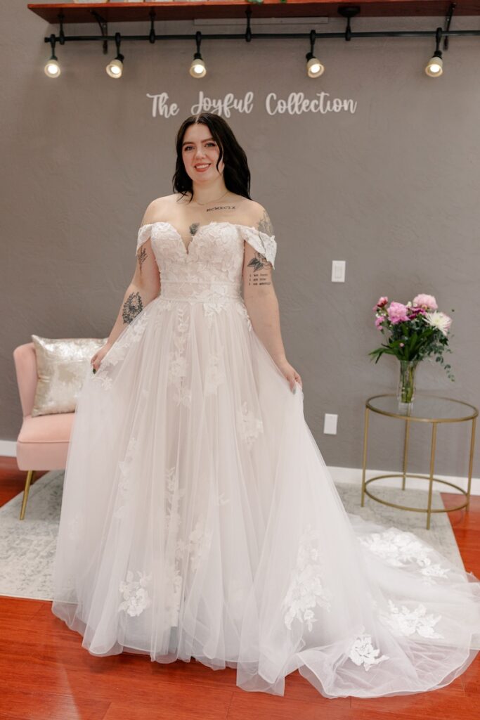 v-neck, lace detailed wedding dress with off the shoulders straps. Weddings with Joy. 