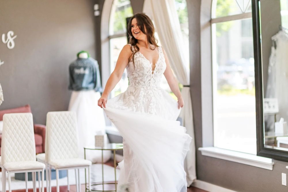 bride twirls in a lace a-line wedding dress with v-neckline and straps. Weddings with Joy