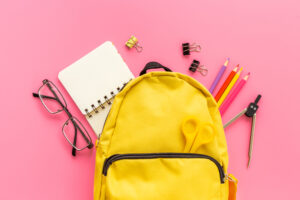 Educational objects top view. School backpack with colorful stationery.