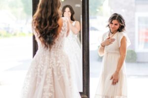 Bride to be full of joy seeing herself in bridal dress with Weddings with Joy bridal stylist help