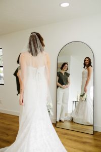 bridal stylist and bride looking at mirror