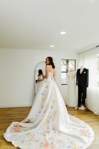 happy woman in bridal dress with floral train looking back